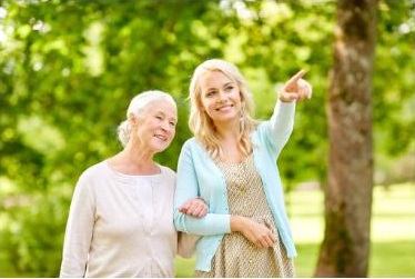 Pflegekraft begleitet Seniorin im Alltag